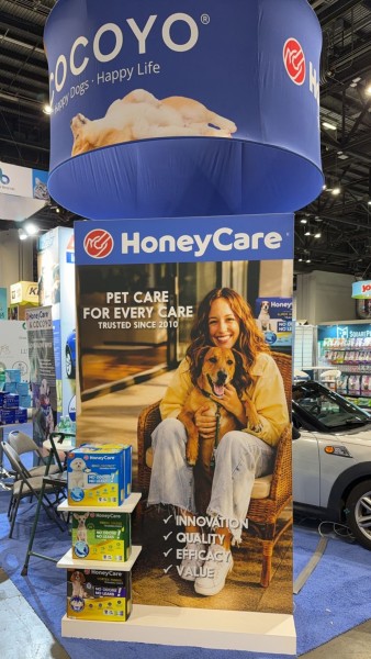 HoneyCare booth display at Global Pet Expo featuring branded signage, pet training pad products.