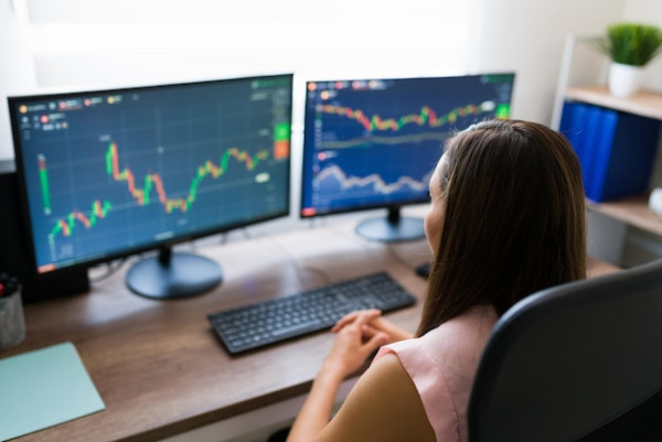 Close up of a business analyst investing in stocks online while working from home. Professional woman and freelancer in the trading business